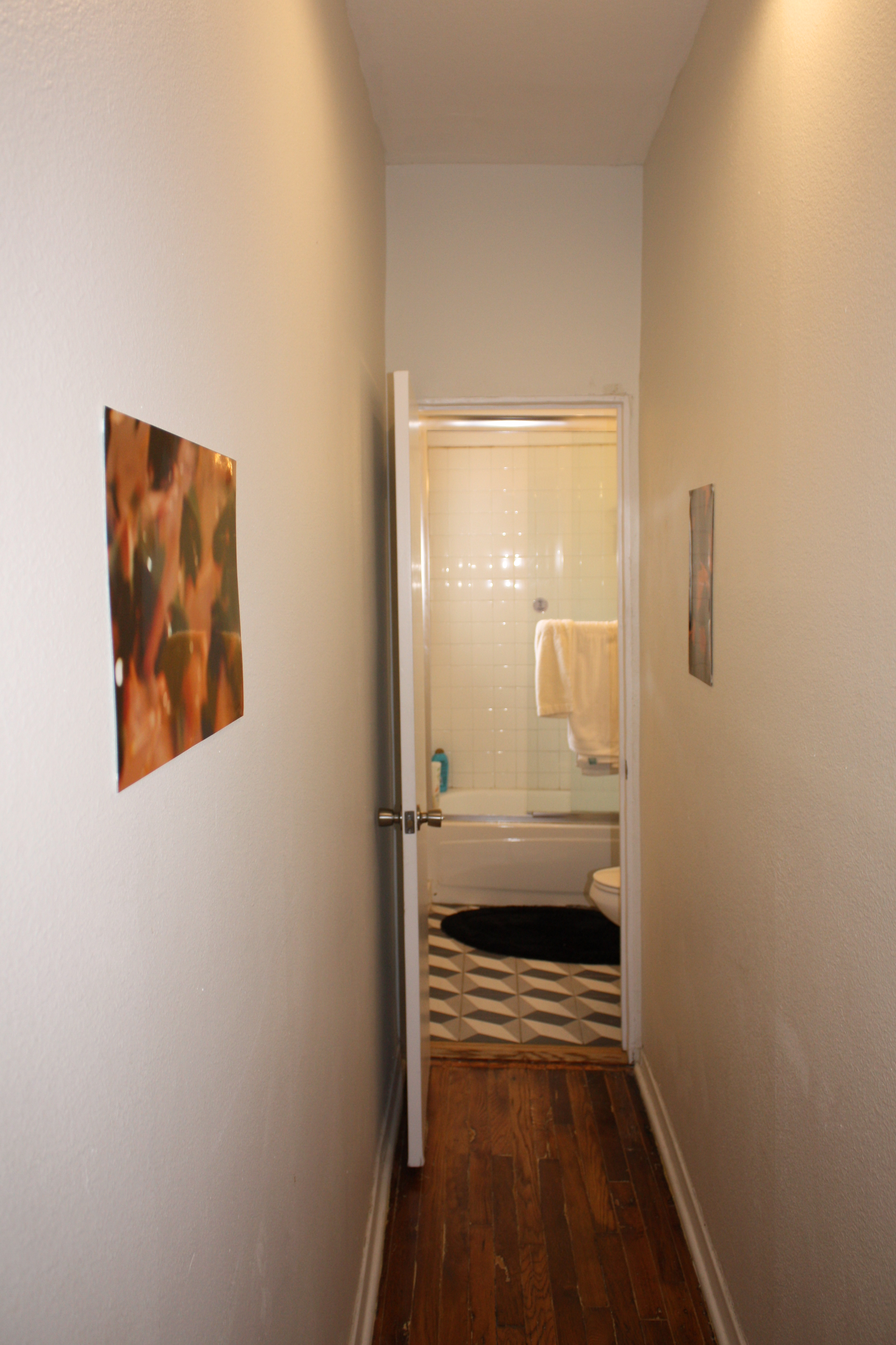 A narrow hallway leading to a bathroom